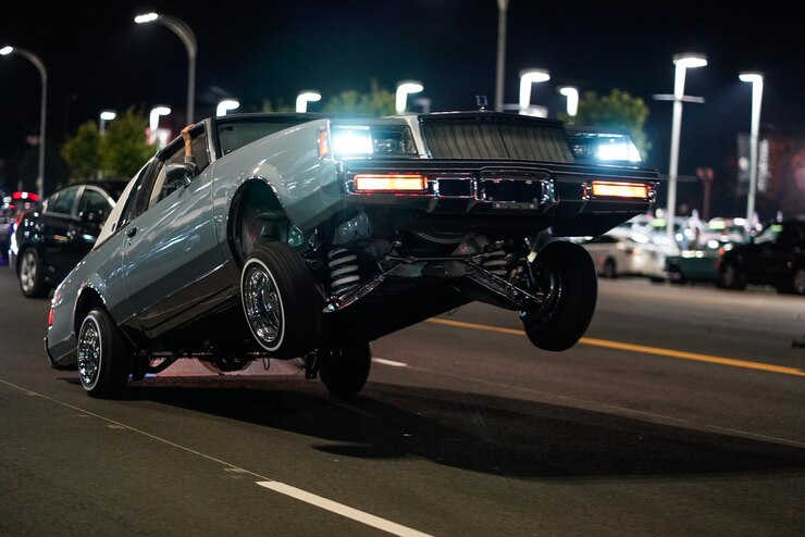 closeup-shot-retro-car-with-only-back-wheels-ground-street-night_181624-32812