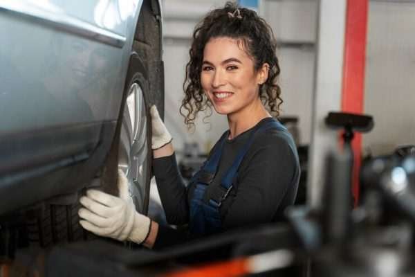 What happens if your vehicle fails the MOT? Step-by-step guide side-view-smiley-woman-changing-wheel_23-2150171279