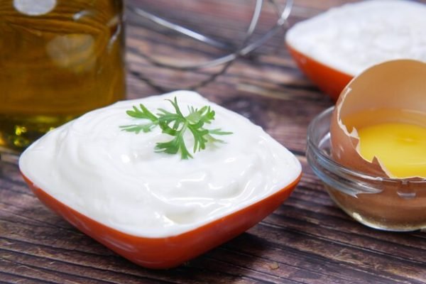 A tray with mayonnaise alongside eggs and other milk ingredients, highlighting the common components of traditional mayonnaise.