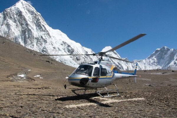 Luxury Everest Base Camp Trek with Helicopter showing snow-capped Himalayan peaks and a helicopter ready for scenic return flight.