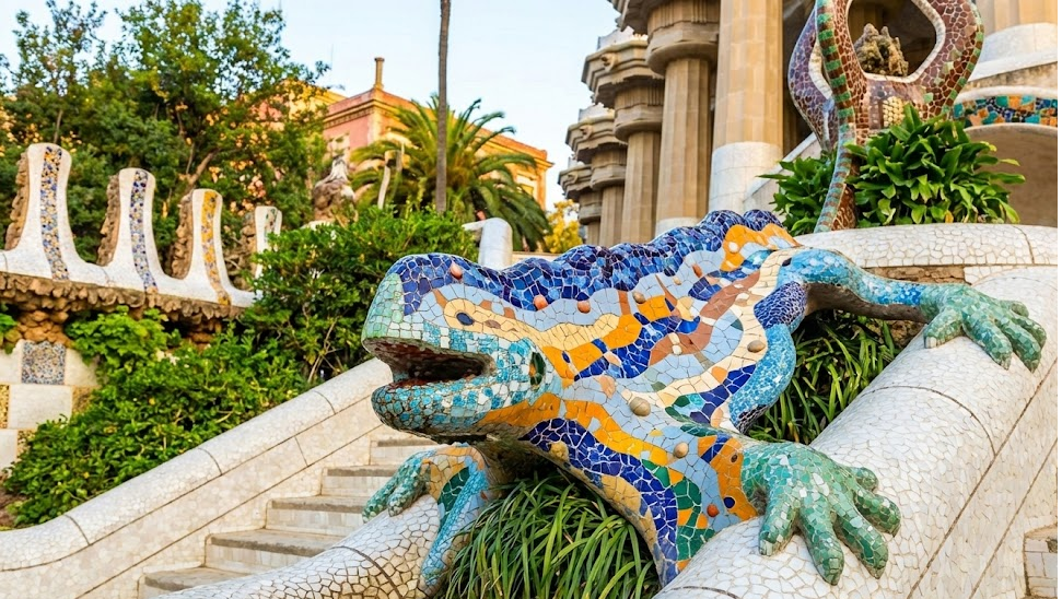 The iconic "El Drac" mosaic lizard fountain at the entrance of Park Guell, showcasing vibrant multicolored Trencadís tile work.