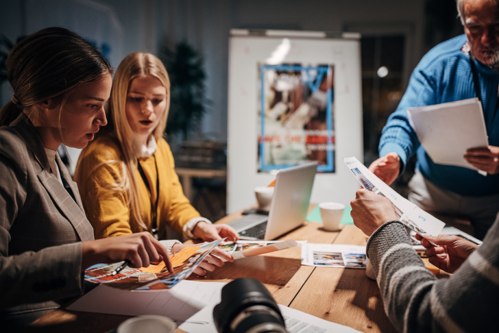 Public relations professionals preparing a press release for media communication in a professional newsroom setting.