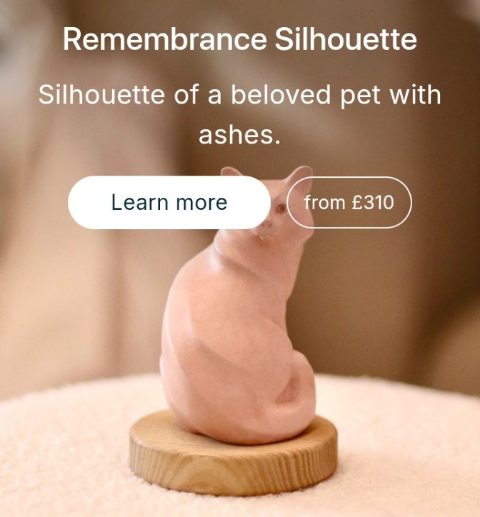 A small, pink ceramic cat-shaped silhouette memorial piece containing pet ashes, displayed on a circular wooden stand. 