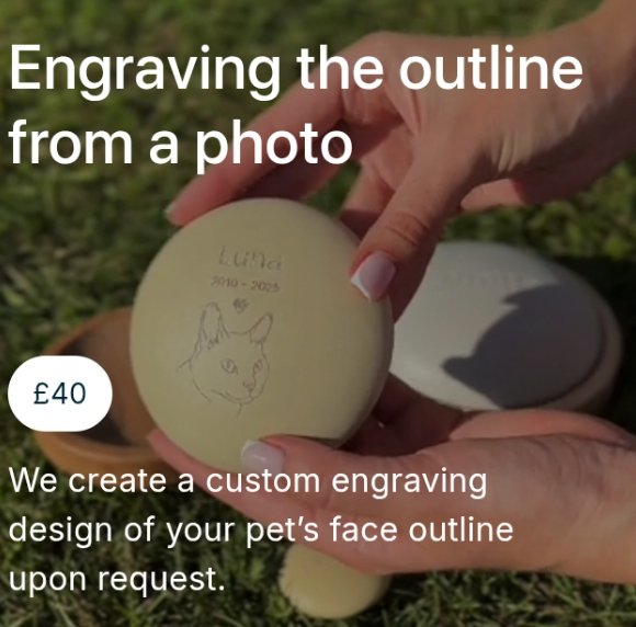 Close-up of a hand holding a light-colored memory stone featuring a custom line-art engraving of a cat's face, the name "Luna," and dates 2010-2025.