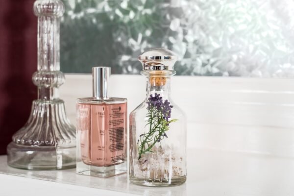 Glass Perfume Bottles and Jar With Lavender on White Shelf