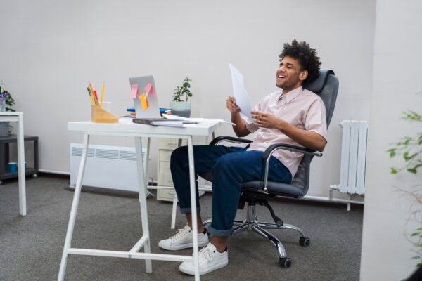 Man sitting comfortably on an ergonomic office chair while working at a desk