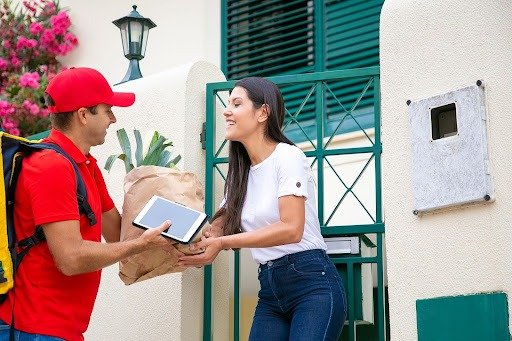 Woman Accepting Delivery Package From Courier