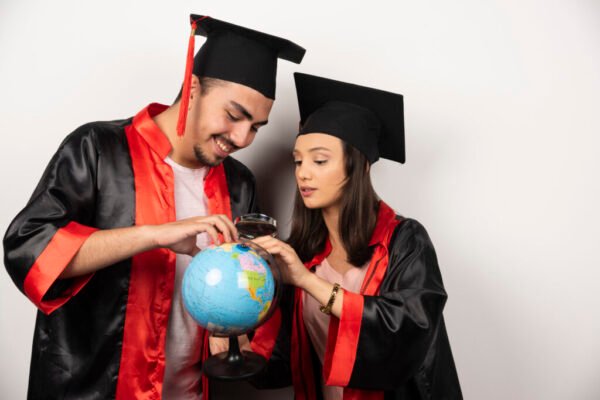 pair happy students gown looking globe white 1 1024x683 1