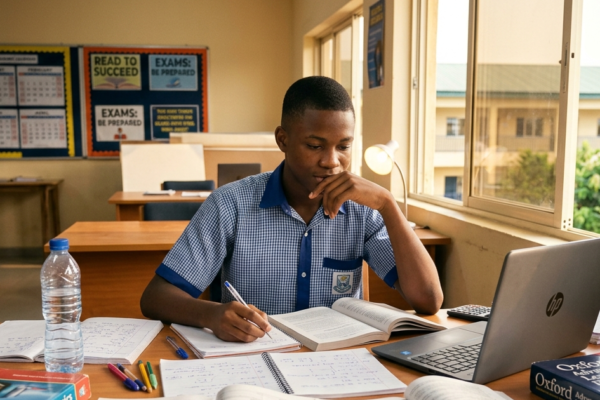 Nigerian student calmly preparing for an examination with books and study materials on a desk