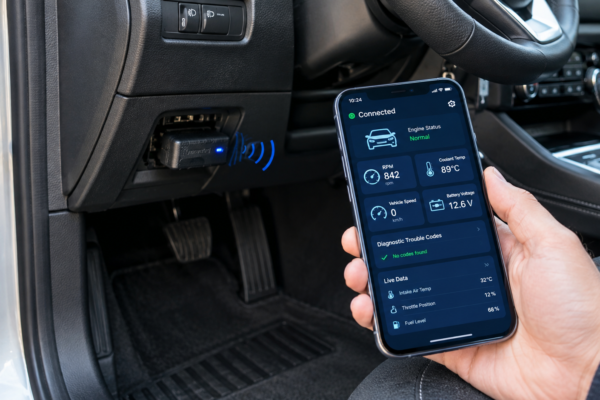 Bluetooth OBD2 adapter connected to a smartphone for car diagnostics