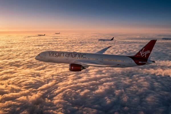 Modern passenger aircraft flying above clouds at sunset