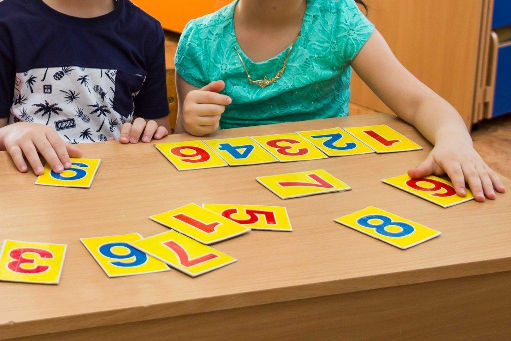 Numbered cards arranged in different orders and selected in groups to illustrate permutations and combinations.
