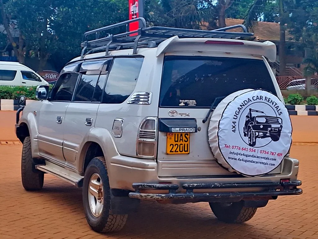 4x4 safari vehicle on dirt road in Uganda with tourists on game drive viewing wildlife in national park